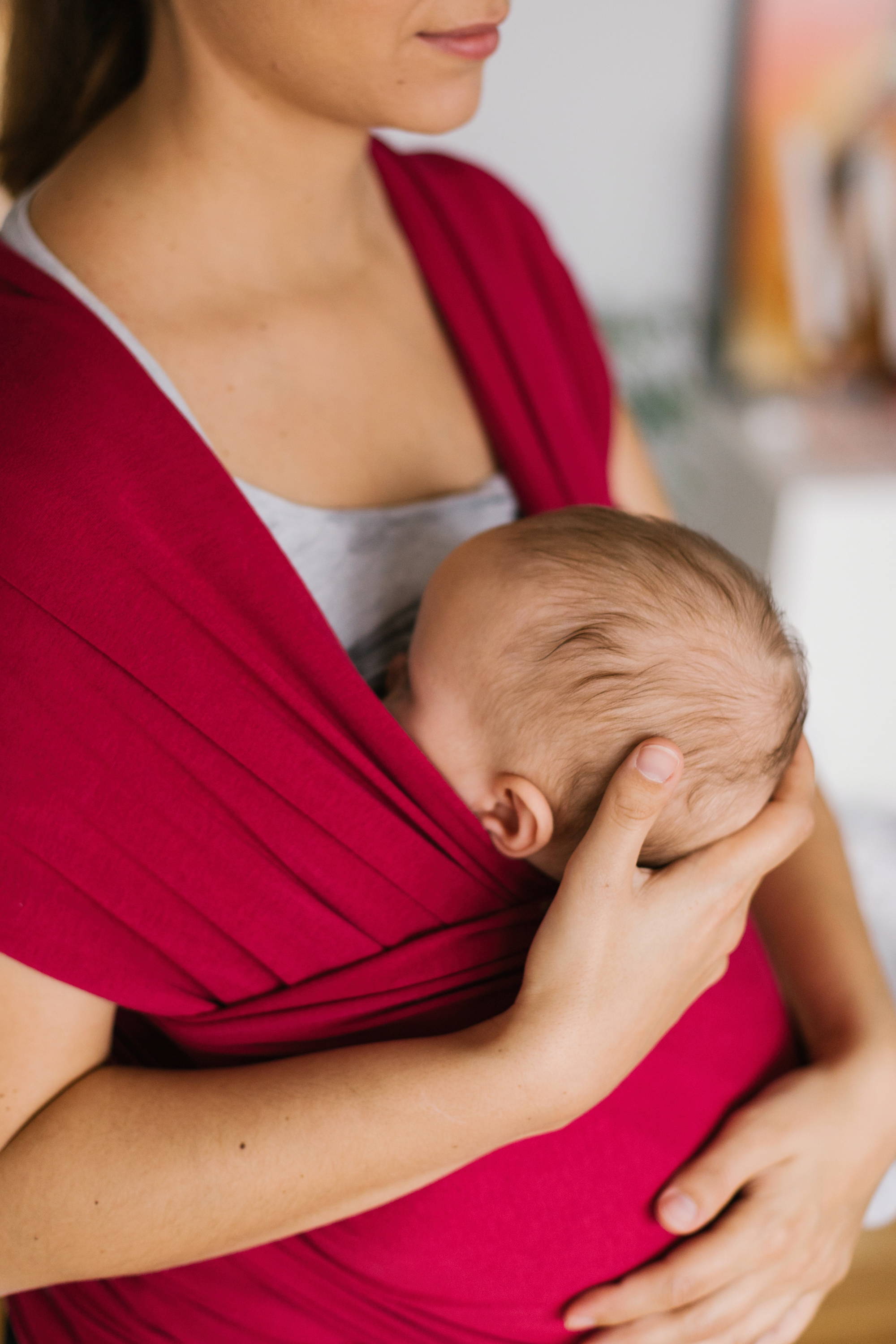 Small baby breastfeeding in an upright position in Sangria pink cotton wrap 