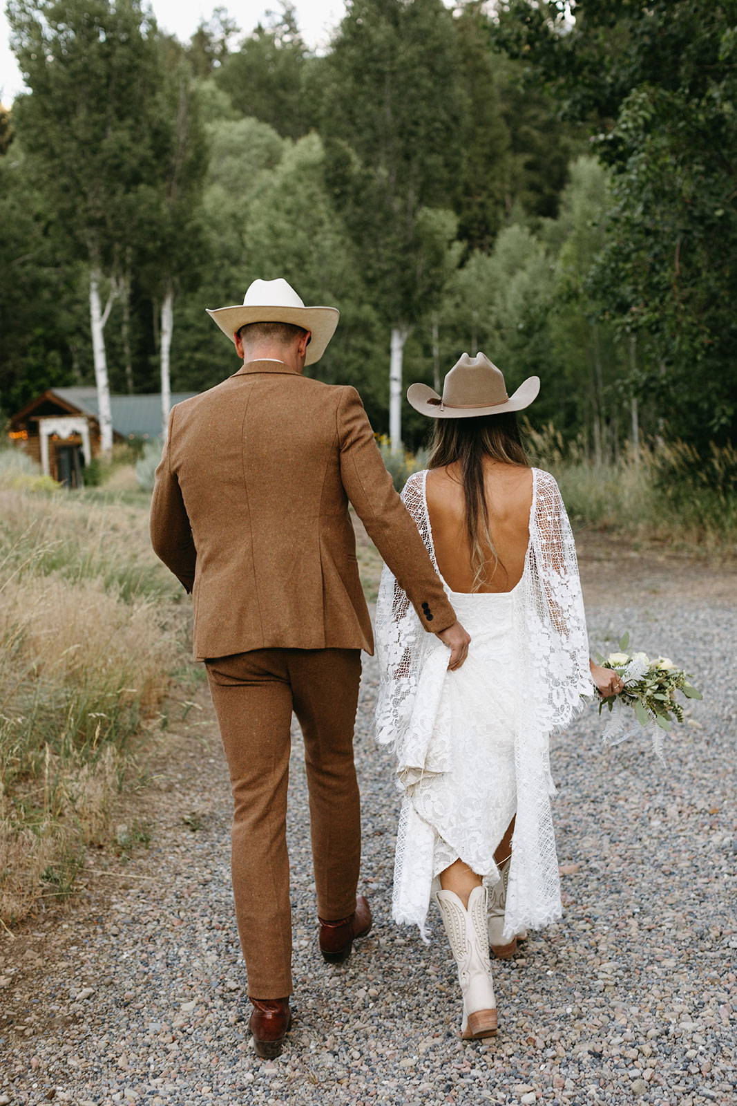 Groom holding brides gown train