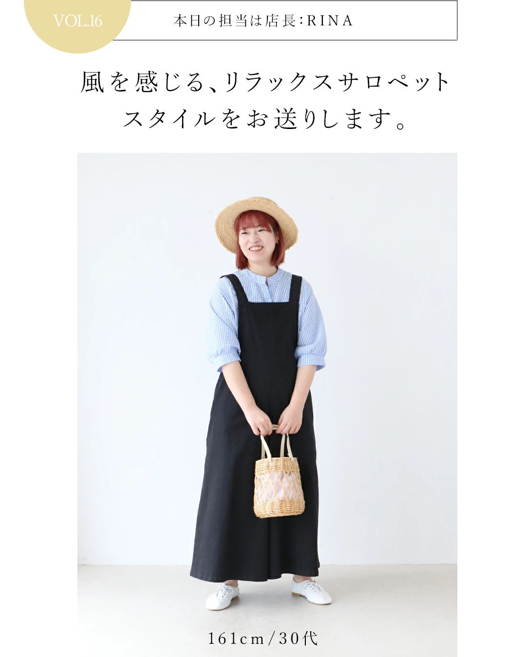A person in a black dress and hat, holding a bag.