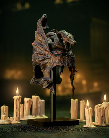 A detailed sculpture of a mythical creature surrounded by candles.