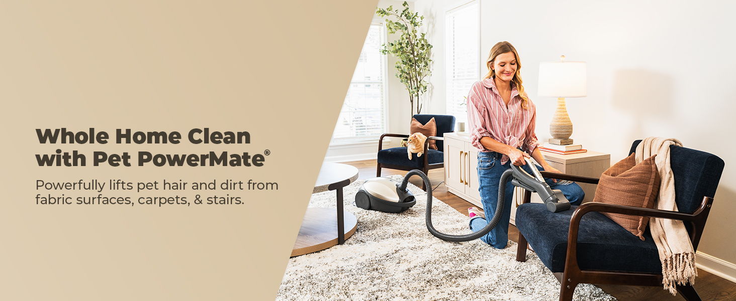 A woman cleaning furniture with a vacuum in a modern living room.