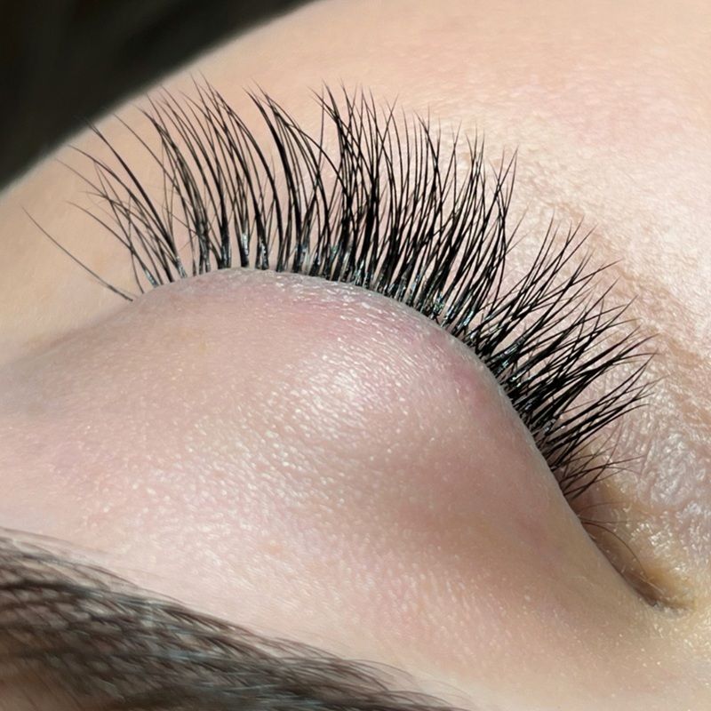 Close-up of long, curled eyelashes on a closed eyelid.