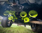 Low-angle rear undercarriage view of six lime green train horns mounted near trailer hitch with air tank