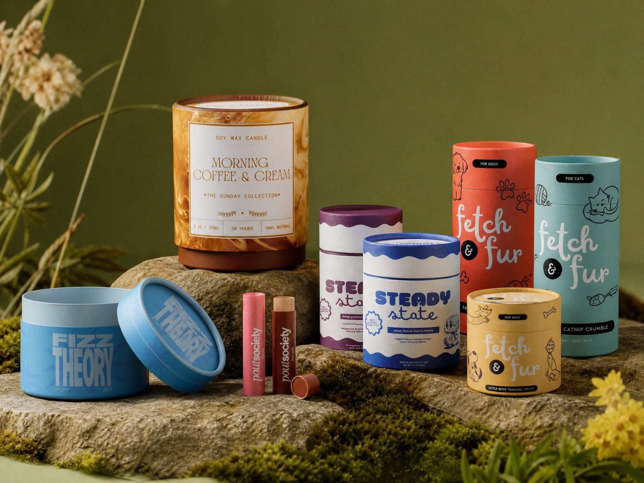 Various colorful paper tubes arranged on a mossy surface.