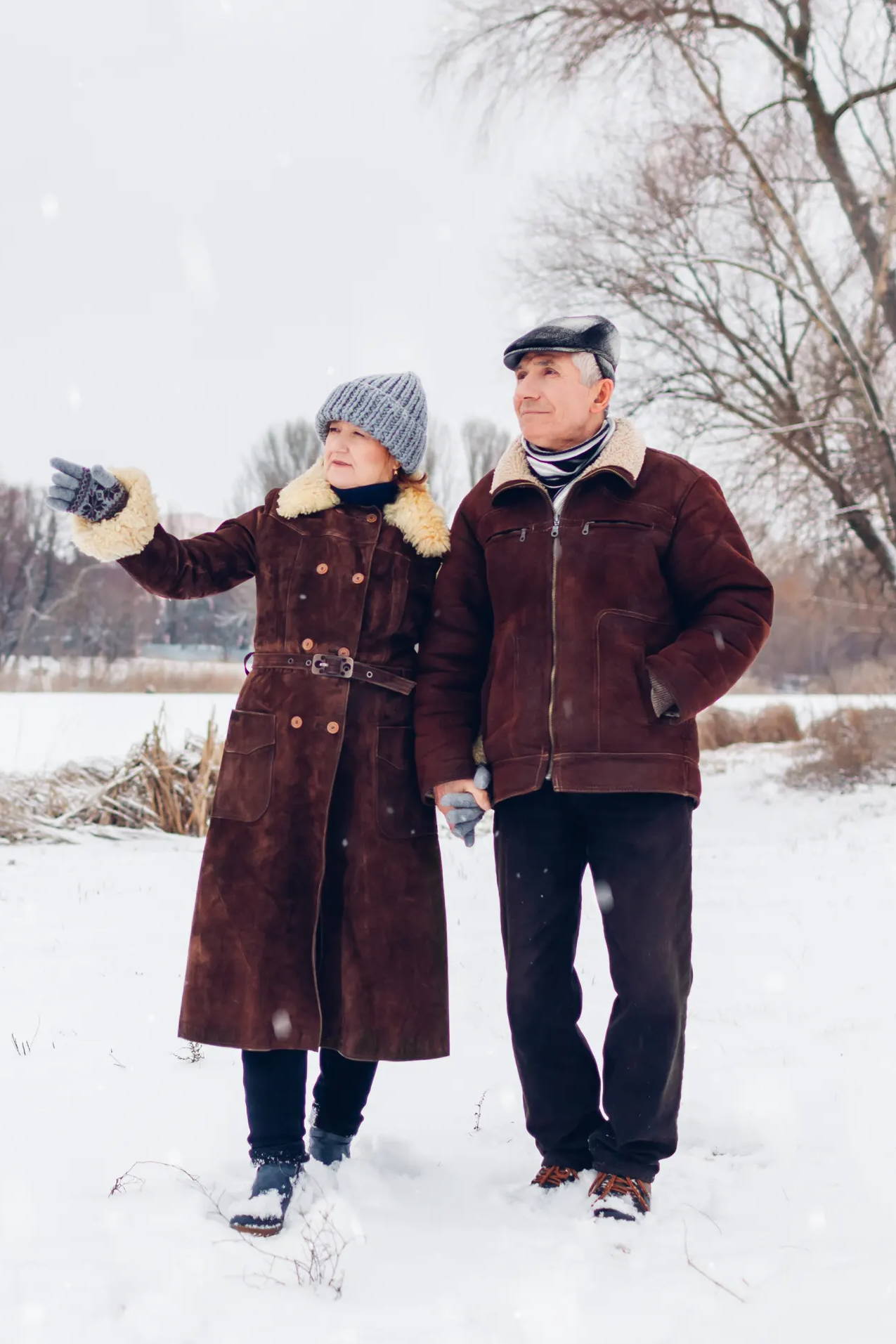 Older couple walking in snow in the winter