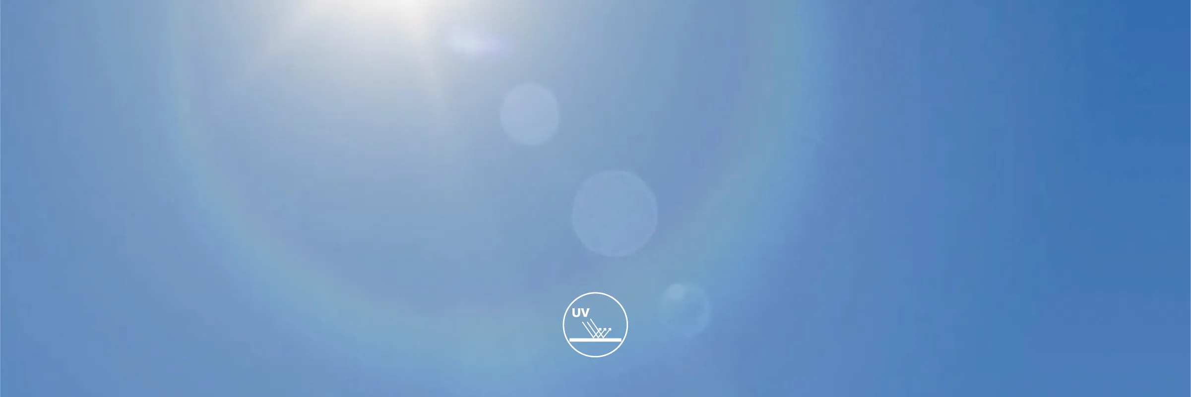 Bright sun with lens flare against a clear blue sky.