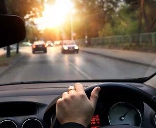 Graphic explaining High Dynamic Range alongside a photo of a car driving towards a bright sunset.