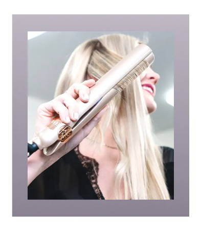 blonde gliding hair in straightening and curling iron 