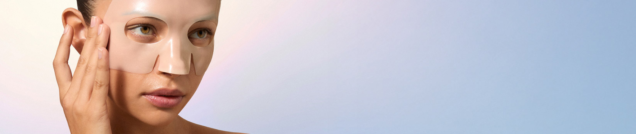 Person applying a facial mask, with a soft gradient background.