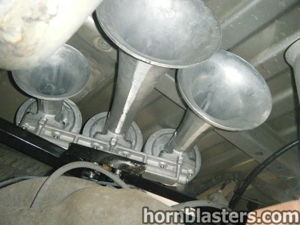 Close-up of metal train horns mounted under GMC Sierra truck