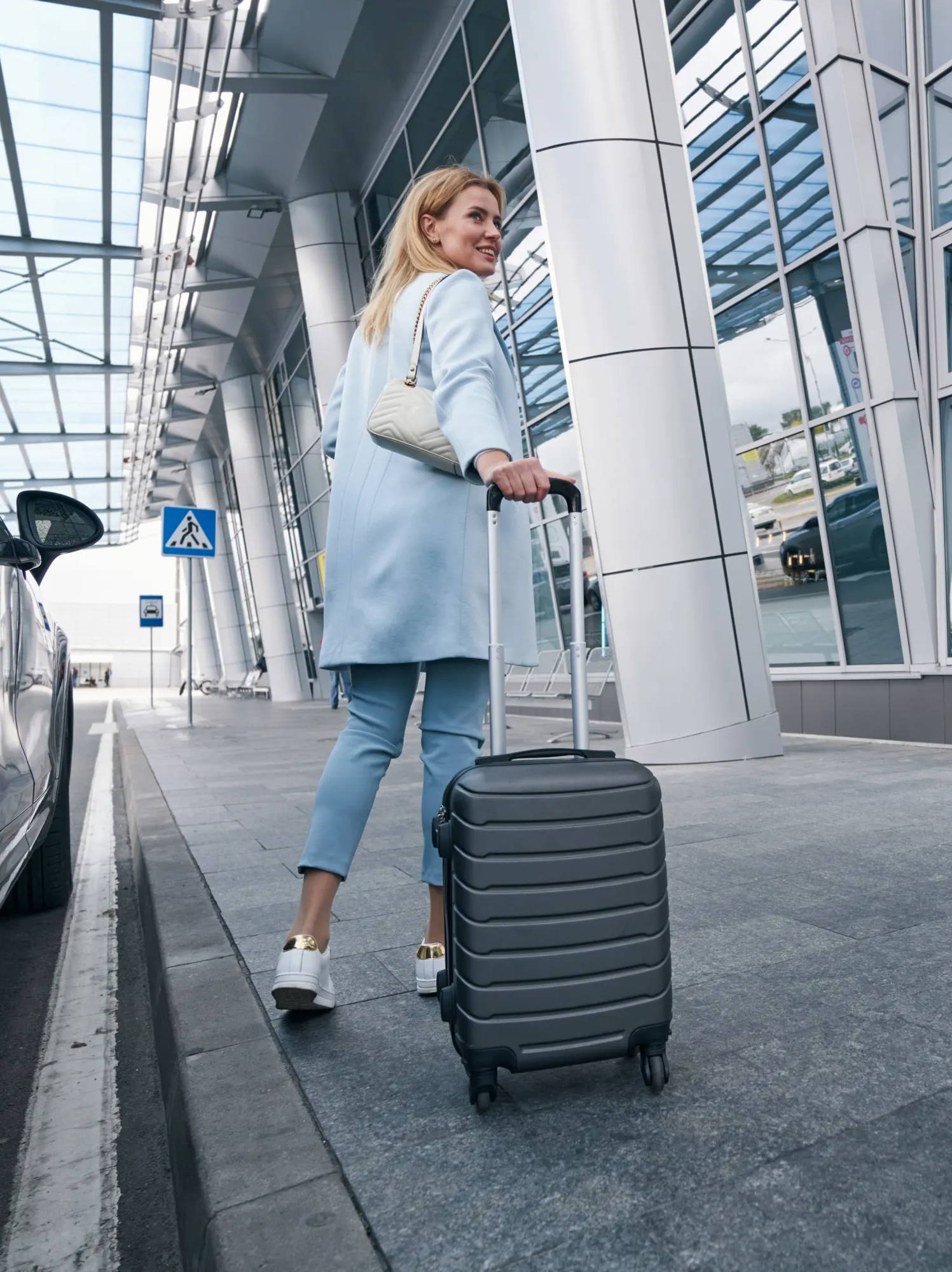 Woman getting out of taxi with luggage, woman in airport