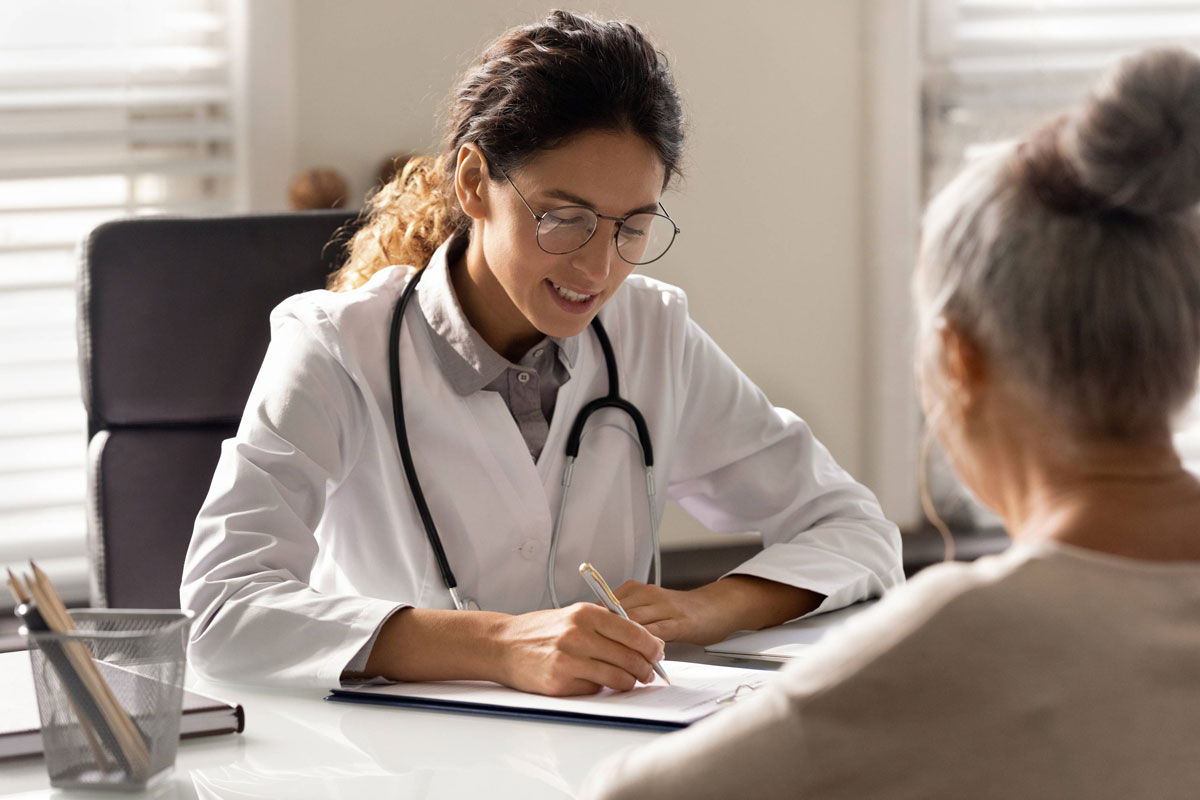 Doctor writing a prescription for a patient.