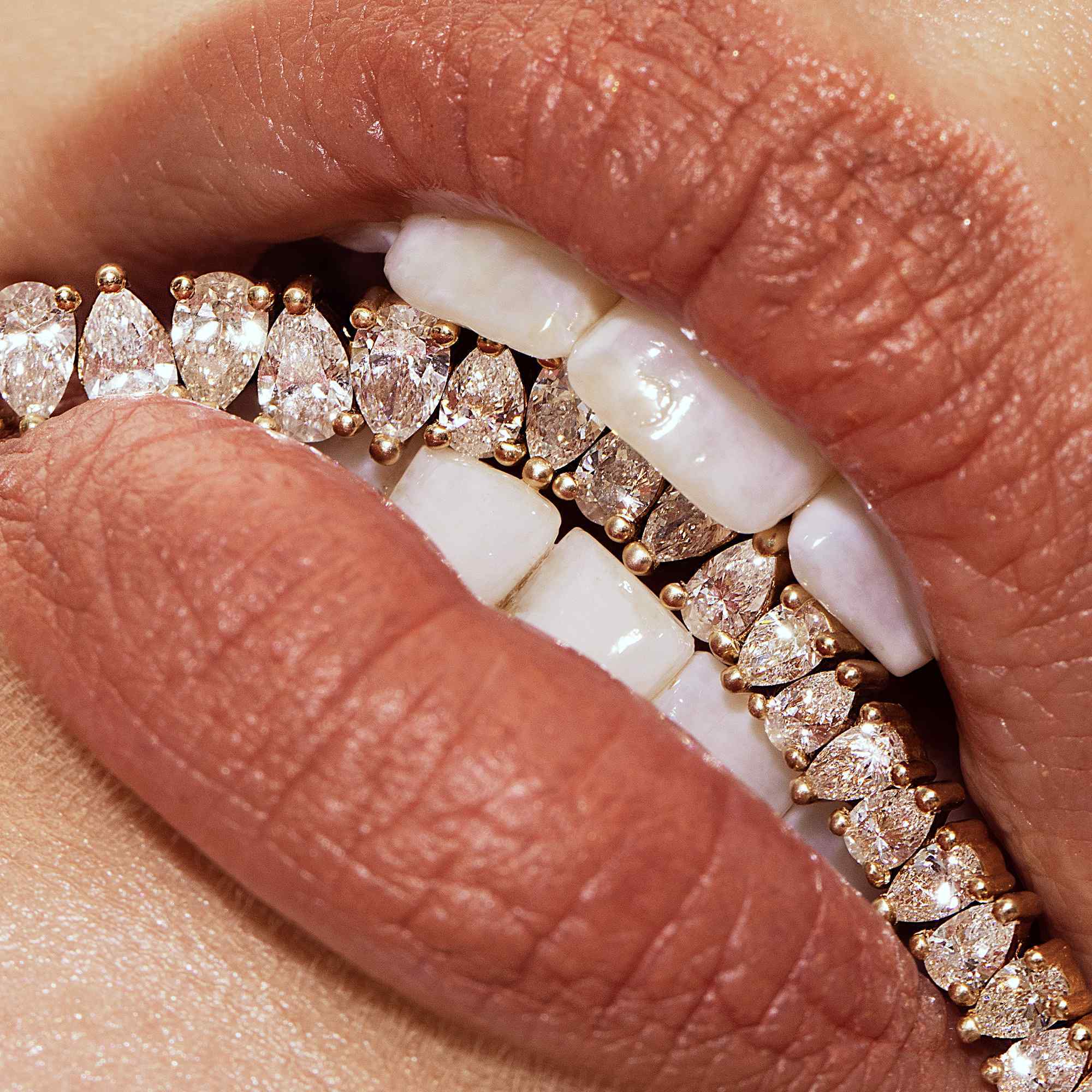 Close-up of lips with diamond grill and matte lipstick.