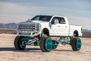 Front three-quarter view of white Ford Super Duty lifted truck