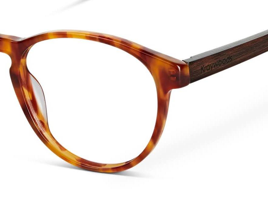 gros plan d'une paire. de lunettes abordables en acétate de tortue orange et branches en bois.
