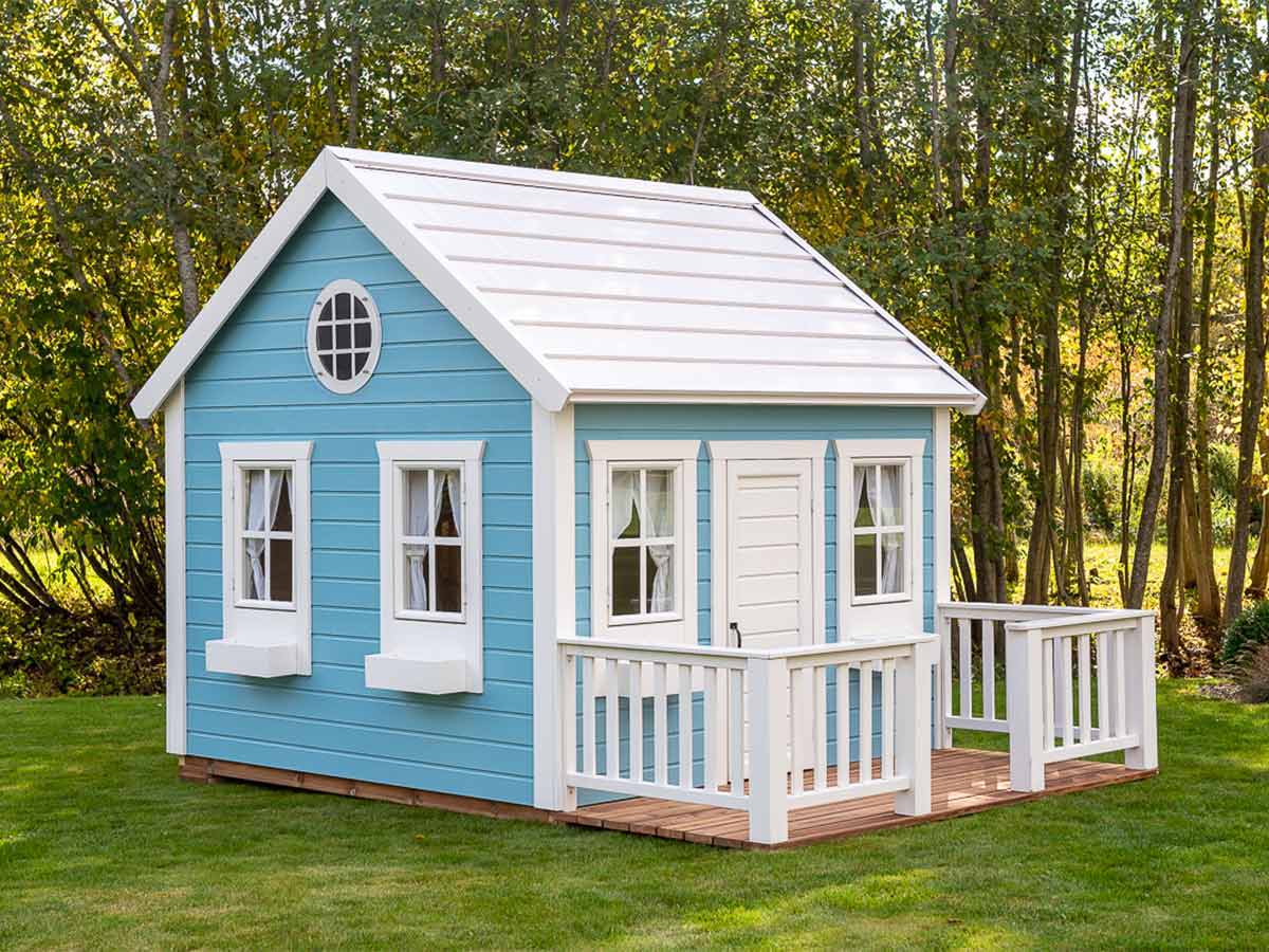 Blue and white Kids Outdoor Playhouse with white wooden Flower boxes and the round top window in a backyard by WholeWoodPlayhouses