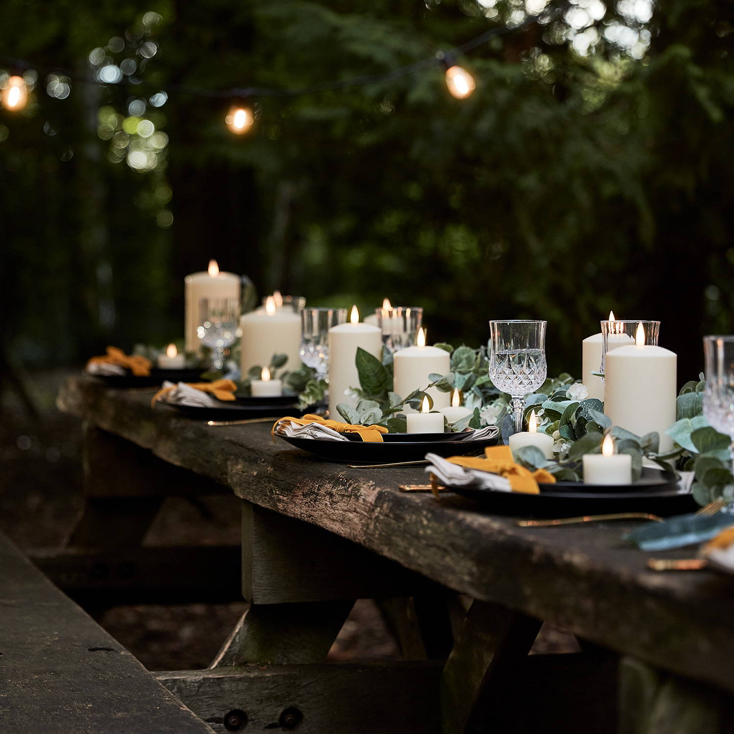 Wedding table with assortment of TruGlow candles and garland close up