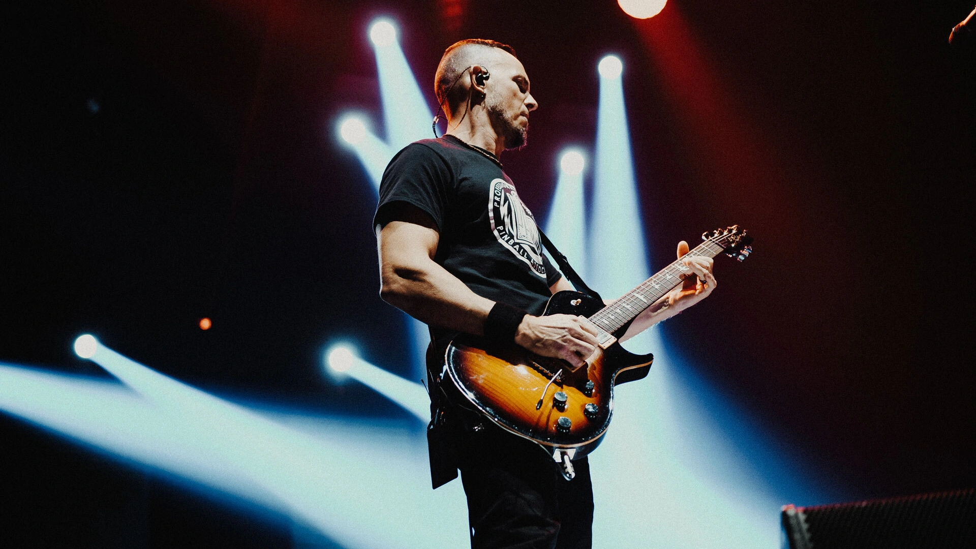 Mark Tremonti playing his PRS signature guitar on stage with dramatic lighting.
