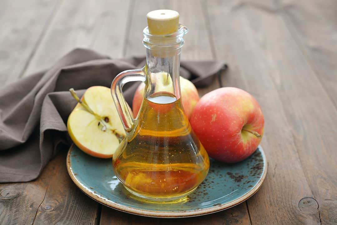 A picture of a bottle of syrup with apples