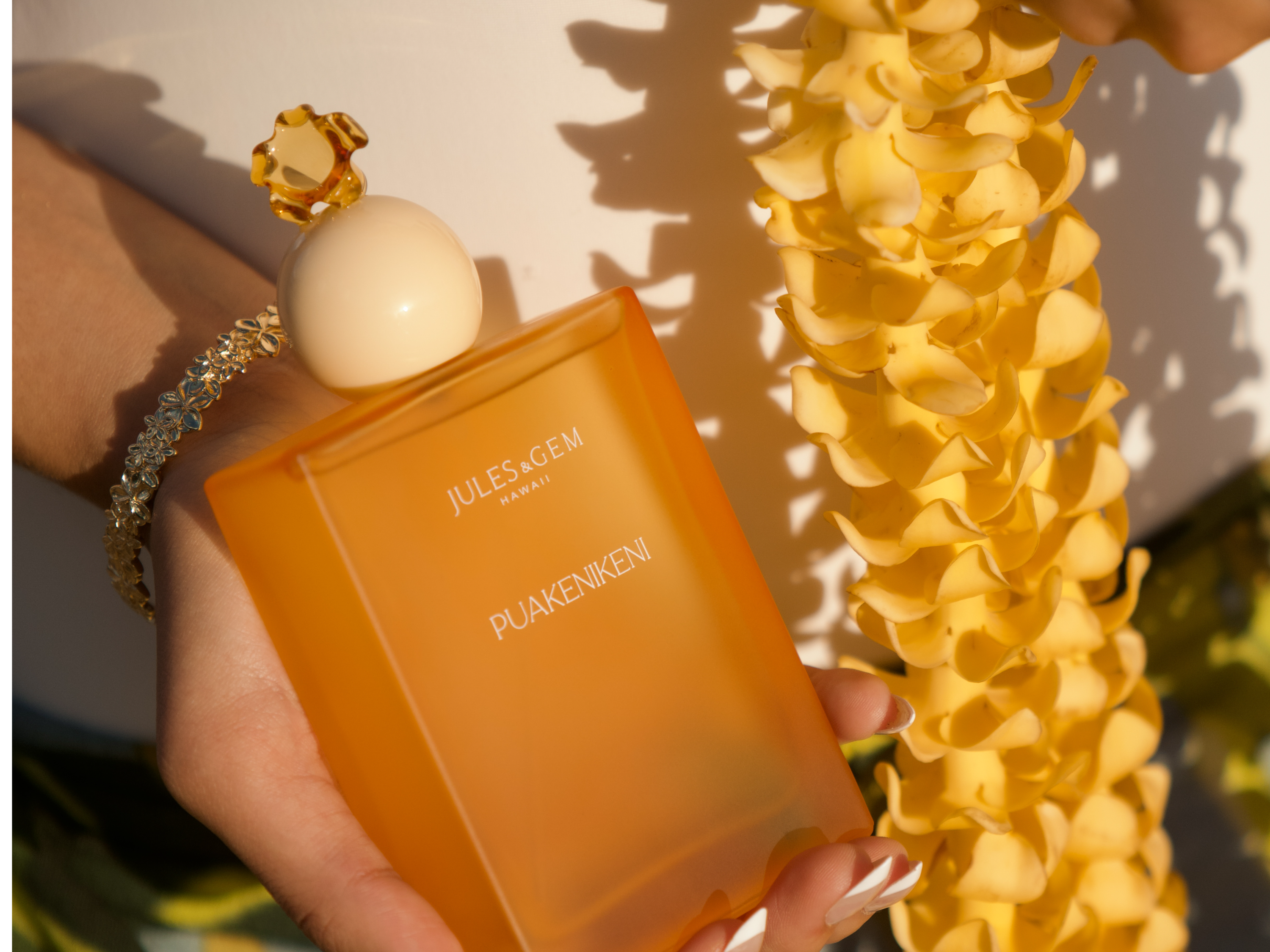 girl holding puakenikeni eau de parfum bottle with puakenikeni lei