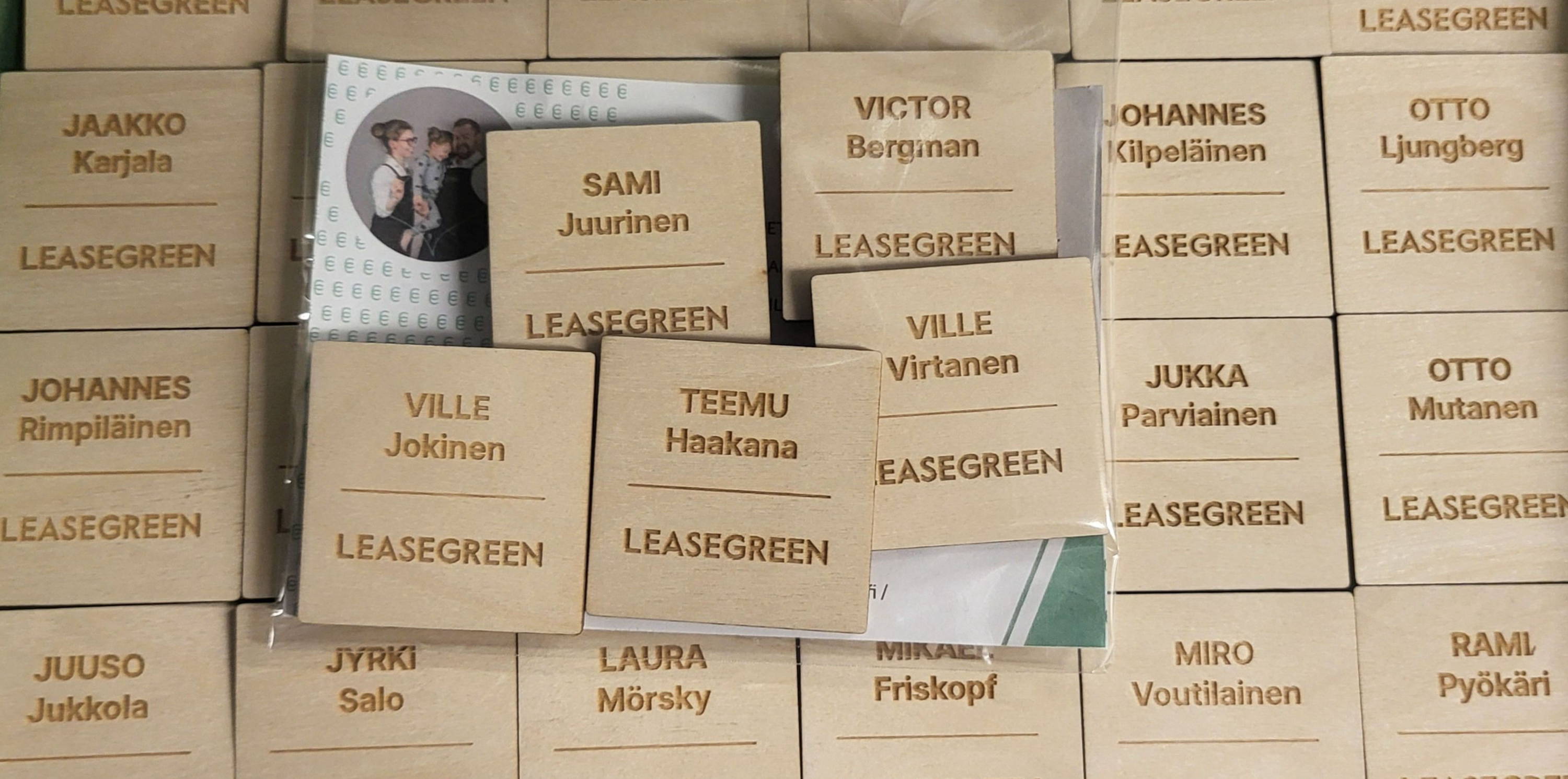 Puinen magneettikiinnitteinen nimikyltti yrityksen logolla henkilökunnan päivittäiseen käyttöön.