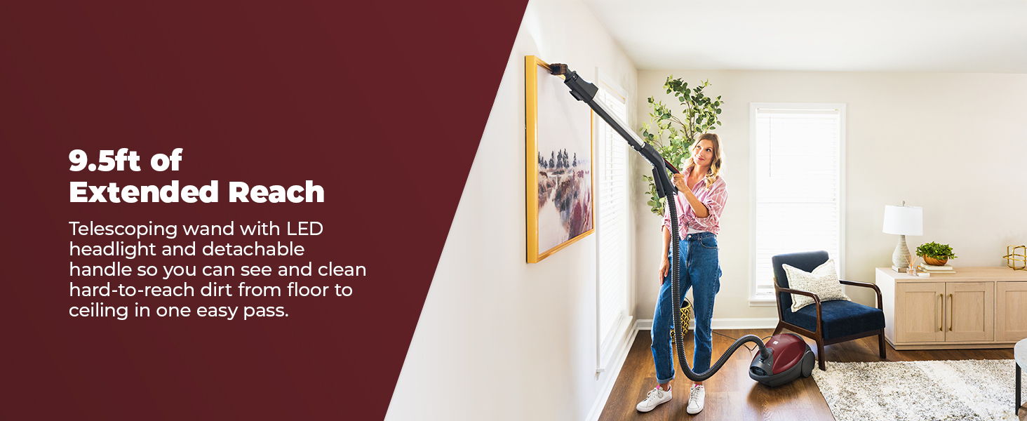 A person vacuuming in a bright living room with extended reach.