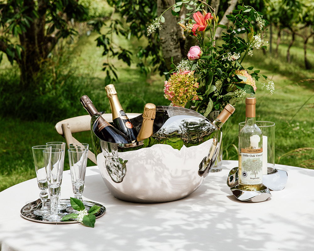 Drift Champagne Bucket with wine bottles and glasses on a table outdoors.