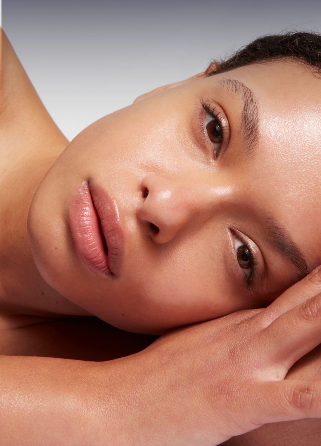 A close-up of a woman resting her head on her hand.
