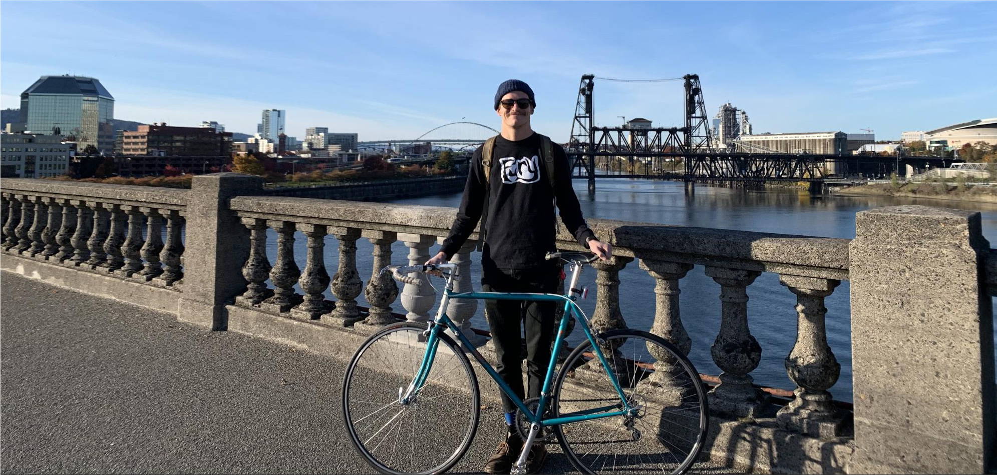 Brent Shenton riding his bike across a bridge in Portland, Oregon