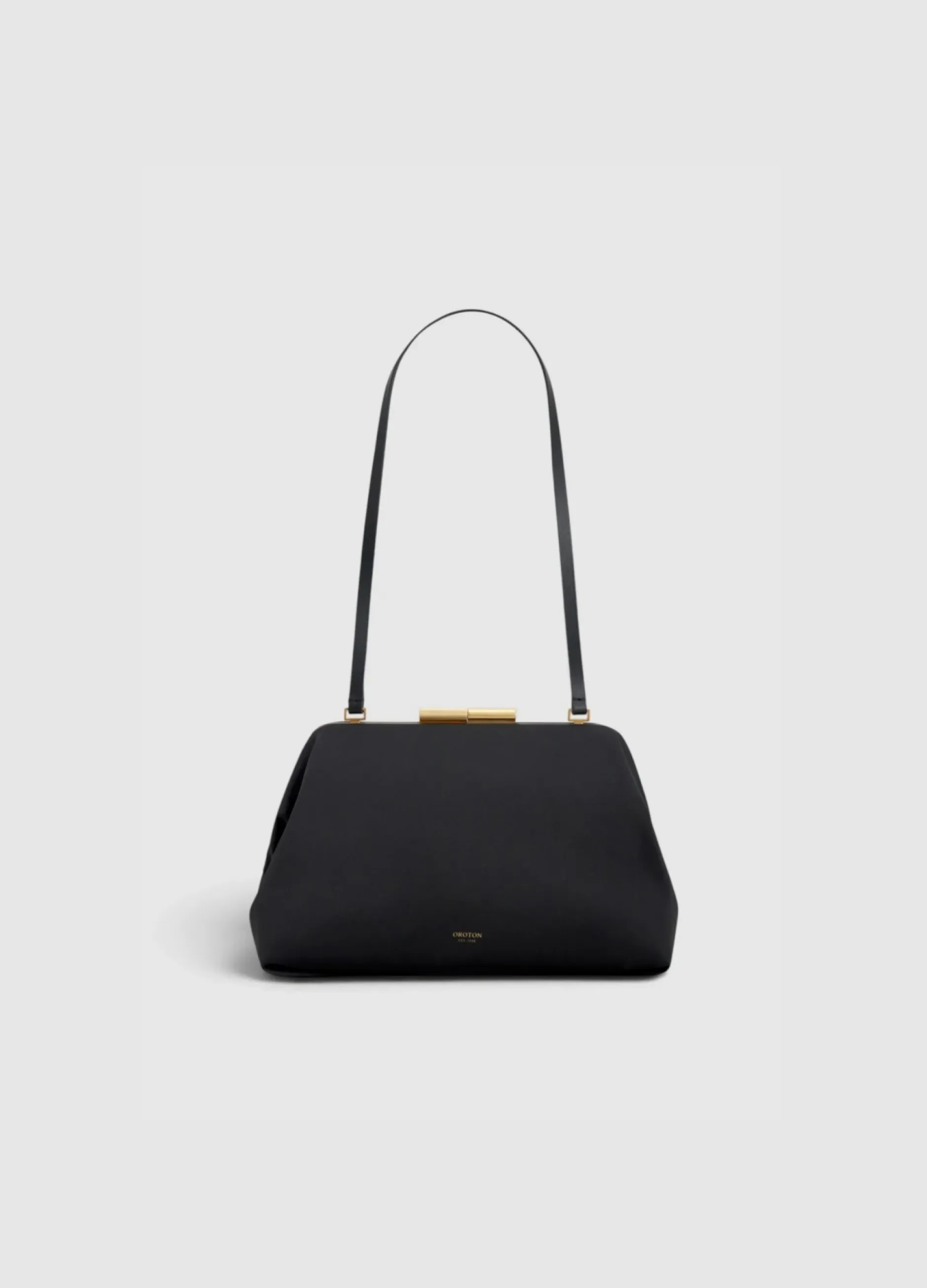 Black handbag with a long strap and gold clasp.