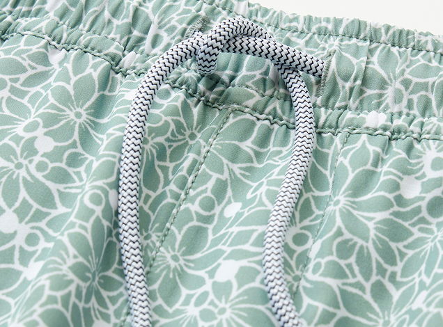 Close-up of patterned swim shorts with drawstring detail.