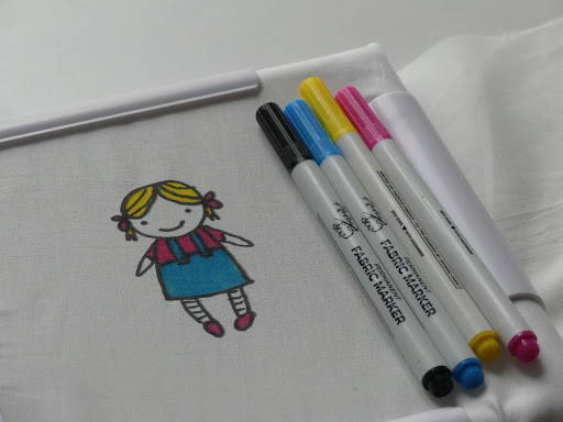 a drawing of a little girl with blond hair on a white cotton fabric