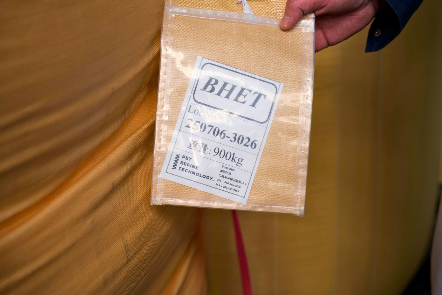 A person holding a brown envelope with text on it.