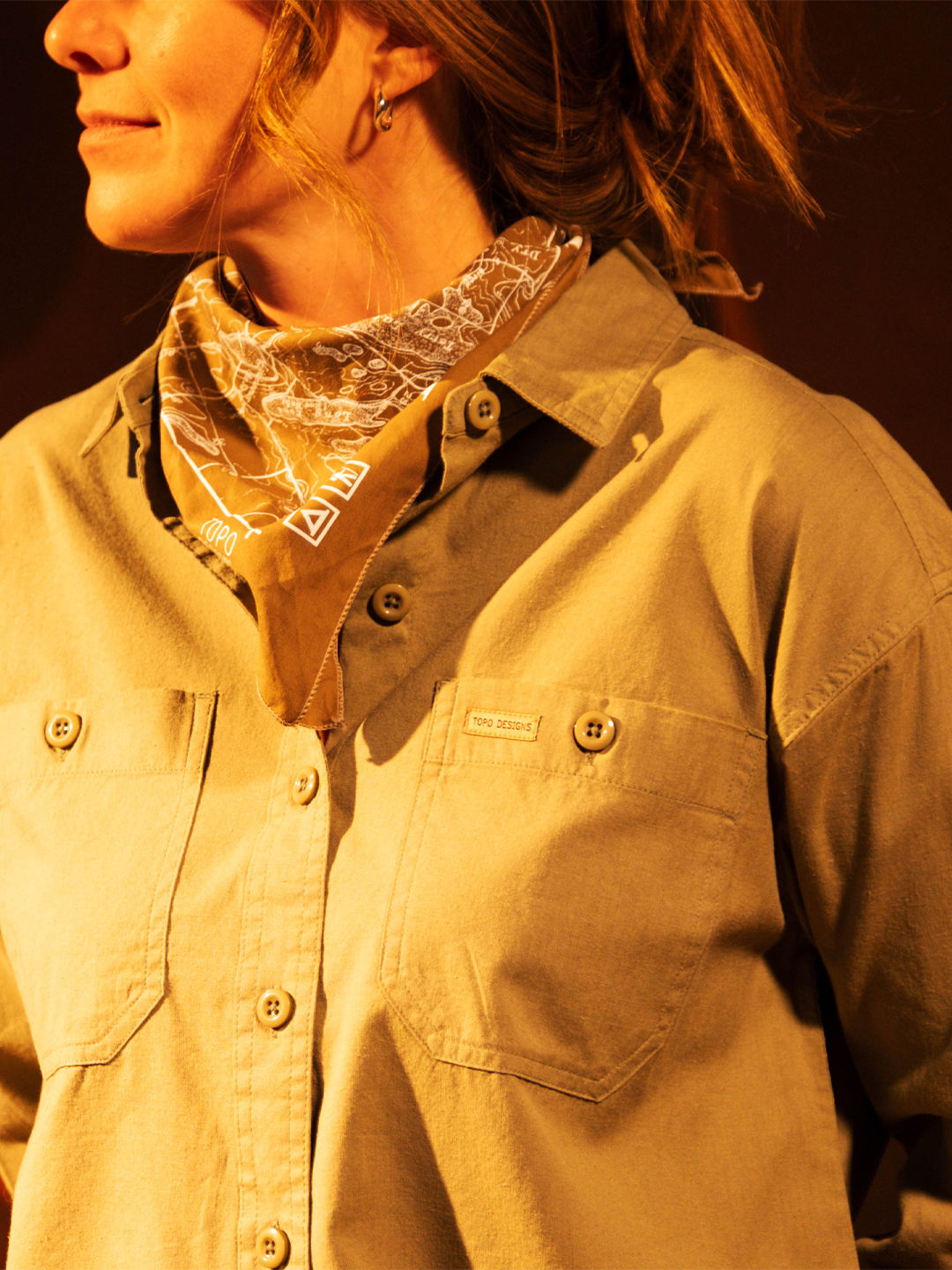 A woman wearing a button-up shirt and a bandana.