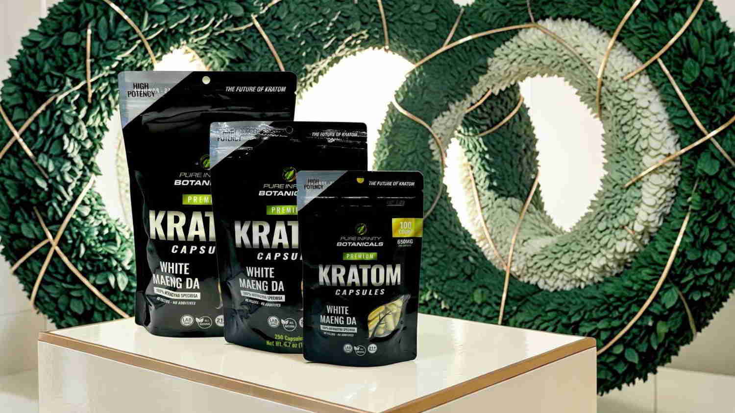 Three bags of Kratom coffee on a display with a green background.