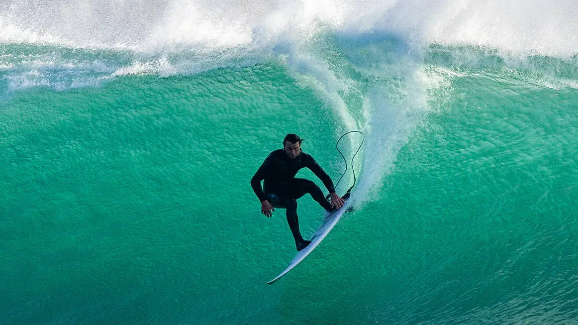 Un Surfeur surfant une gros vague . Welcome Surf Shop