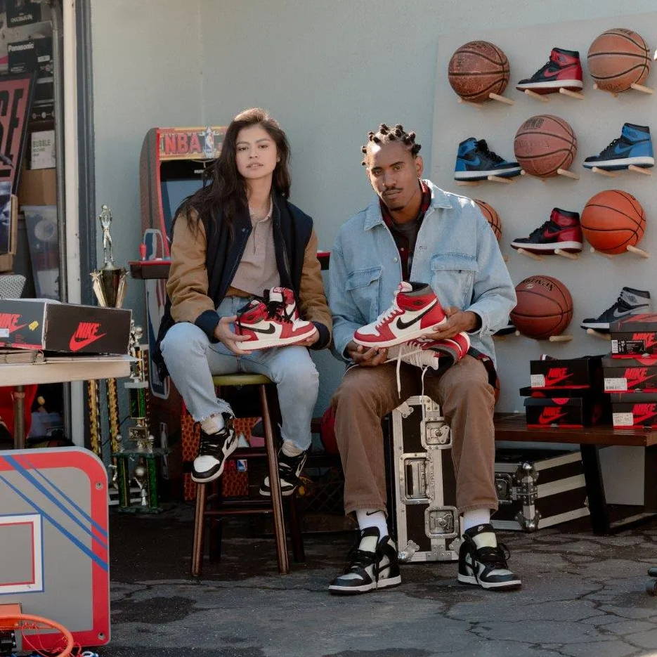 2 models holding the aj1 lost and found