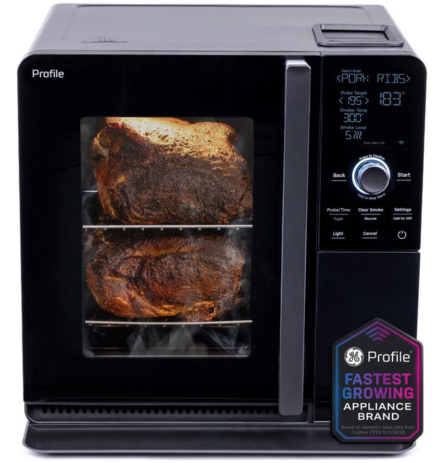 Black oven with two roasts inside and control panel on the side.