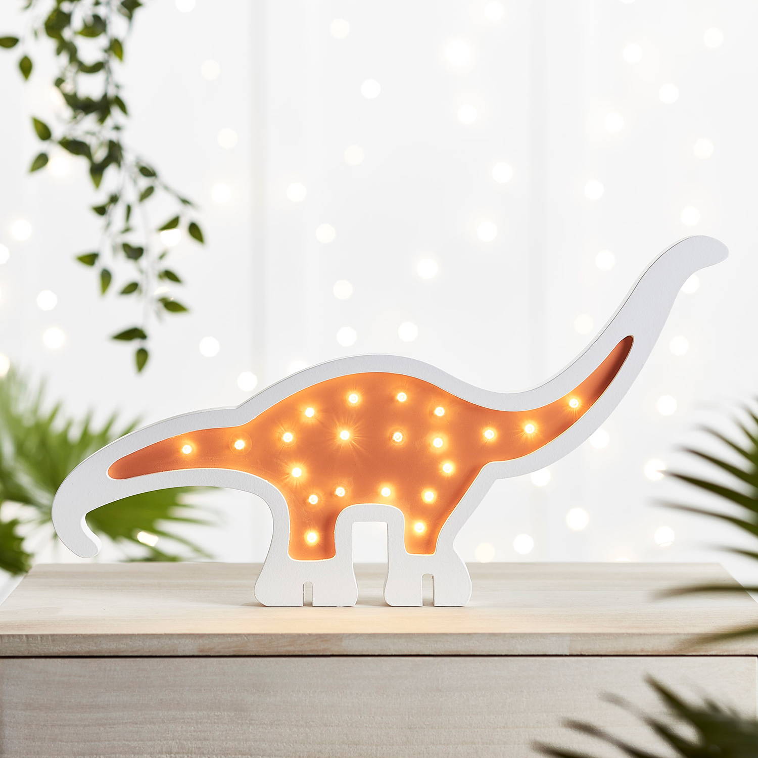 Children's dinosaur light on shelf.