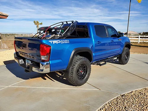 Rear quarter blue Tacoma TRD 4x4 Off Road bed rack paramotor desert driveway Jeremy's 544K Nightmare Edition gallery photo 3