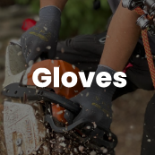 Person wearing gloves while operating a chainsaw outdoors.