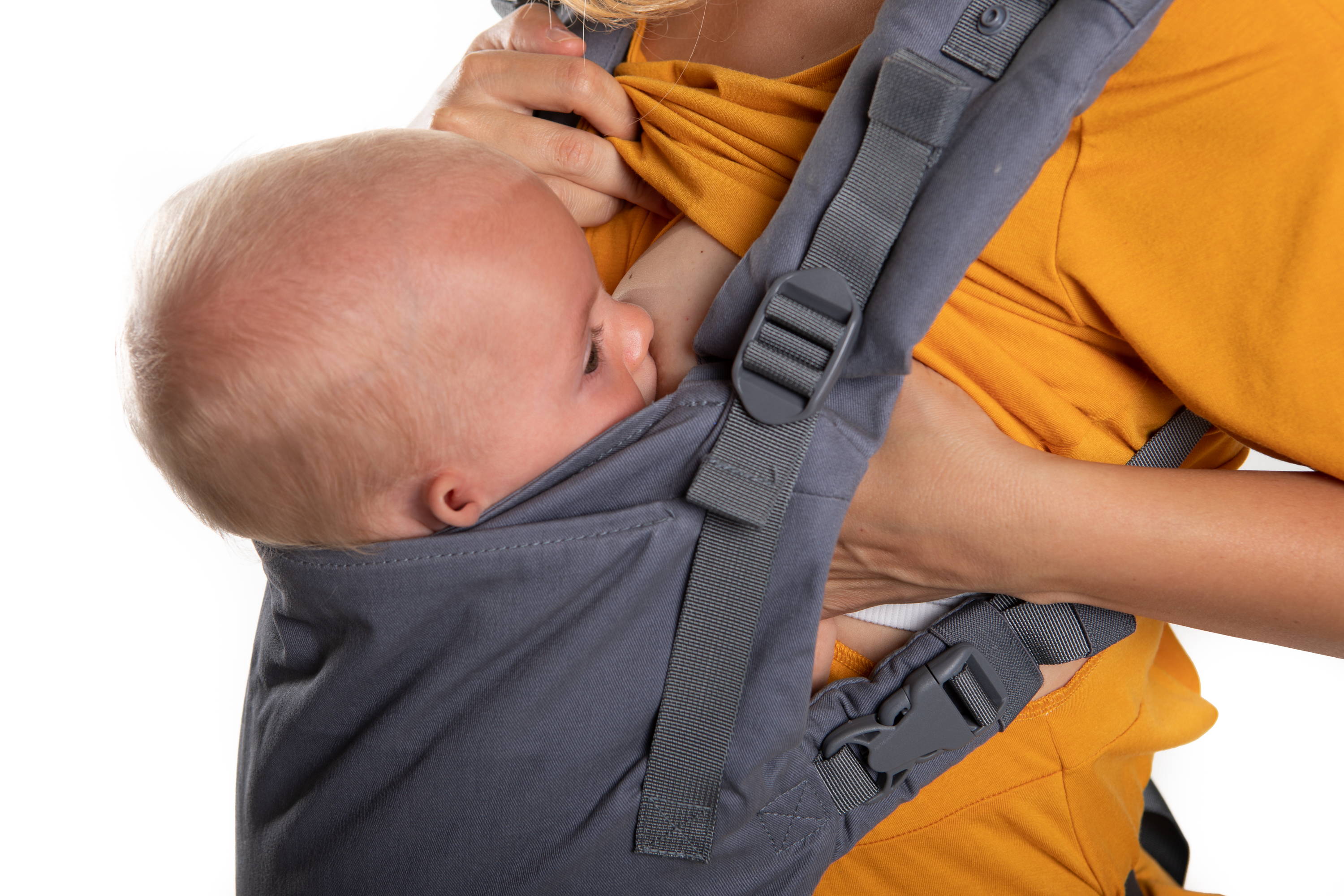 baby breastfeeding in Boba X carrier with mom wearing a mustard colored breastfeeding shirt