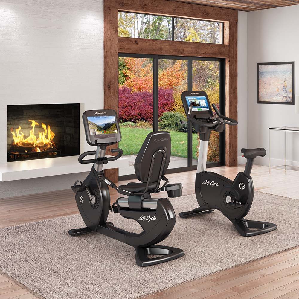 Platinum Club Series Upright and Recumbent Lifecycle exercise bikes in living room by fireplace