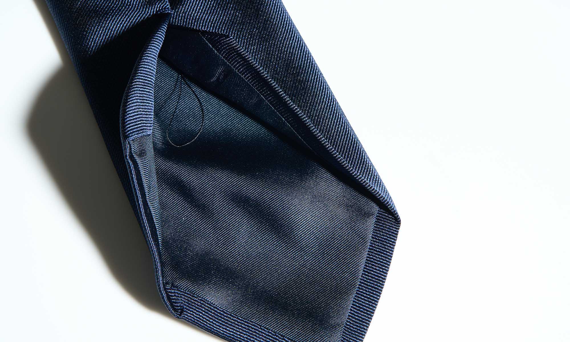 Dark blue tie on a white background.