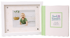 Baby photo in a white frame next to a baby memory book.