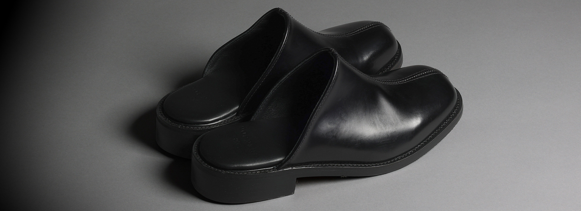 A pair of black leather grenson x YMX mules