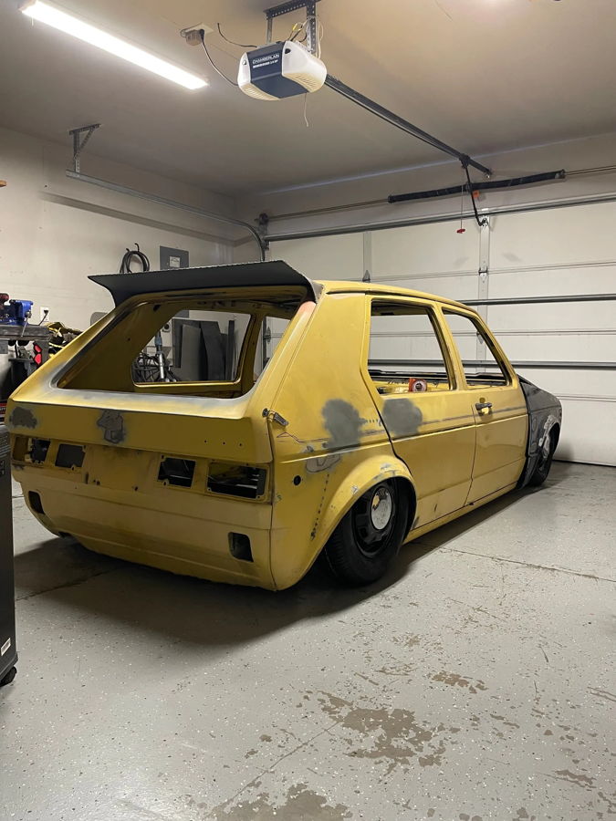 Rear three-quarter garage shot of yellow Rabbit Slam with widened arches and hatch open gallery photo 4