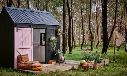 A Barn cubby House, painted black and pink