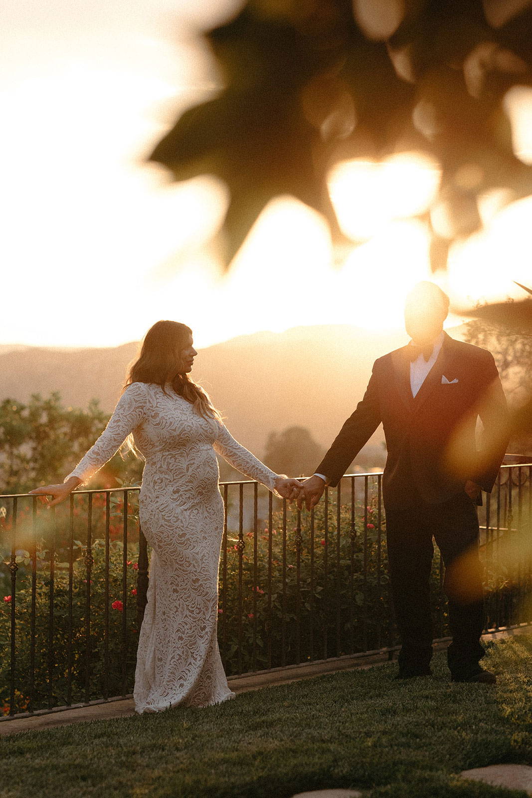 Bride and groom holding hands overlooking mountains