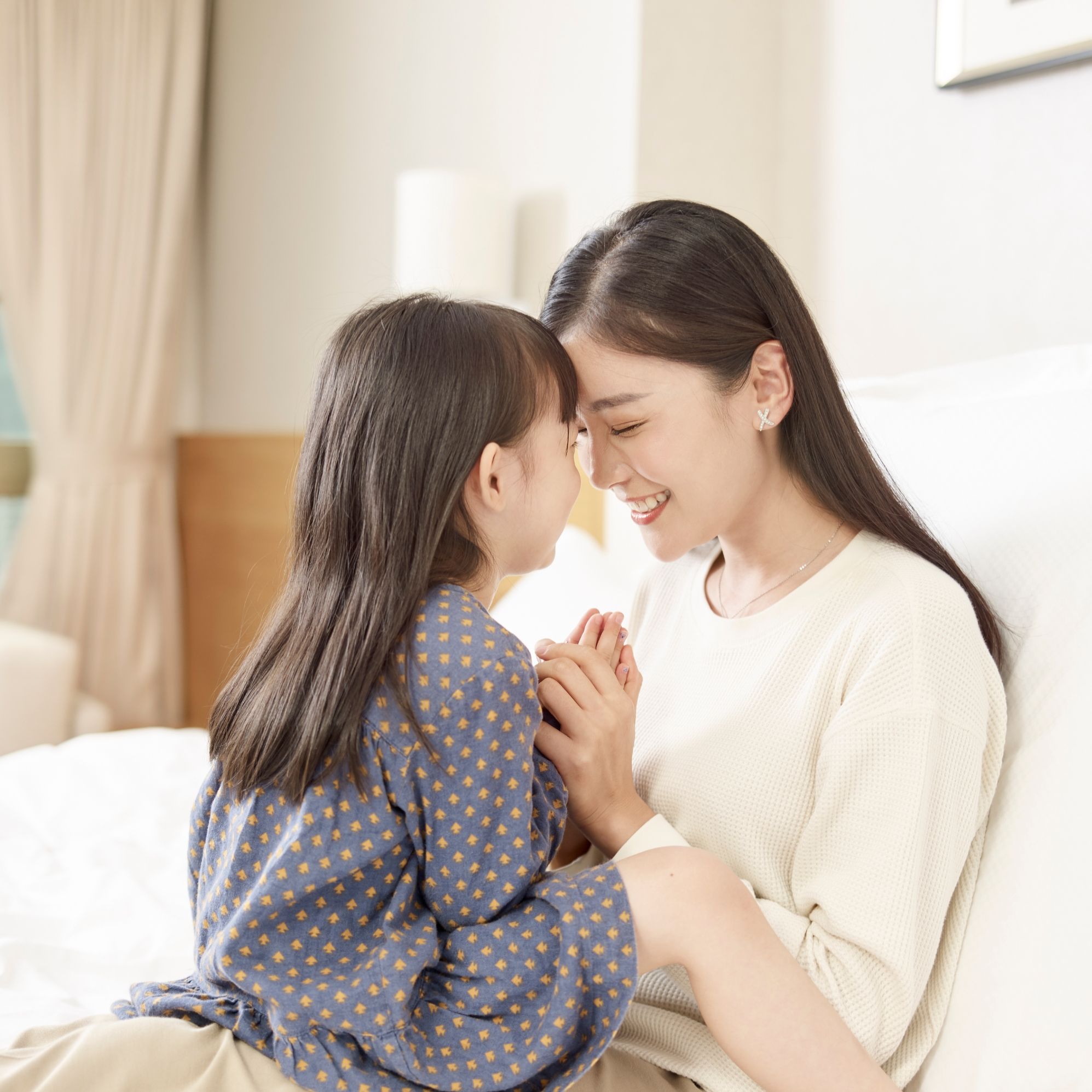 A mother and daughter share a joyful moment together at home.
